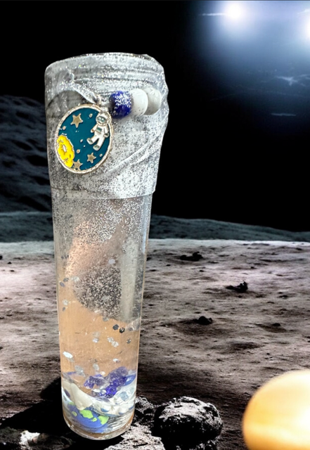 Decorative bottle with celestial design on a moon-like surface