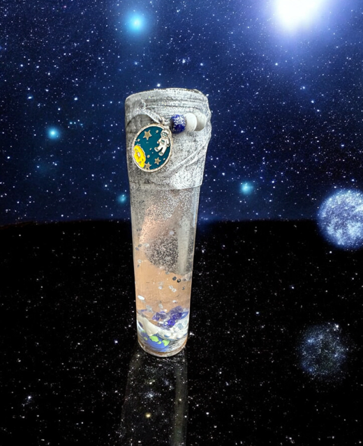 Decorative glass with space-themed design against a starry space background