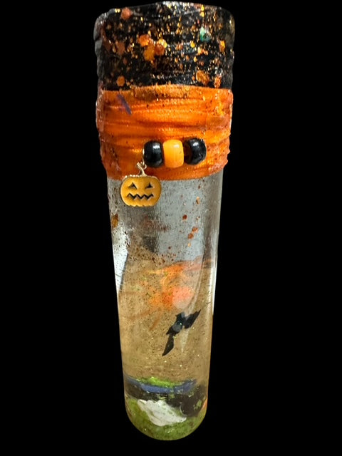 Decorative bottle with Halloween-themed elements on a black background
